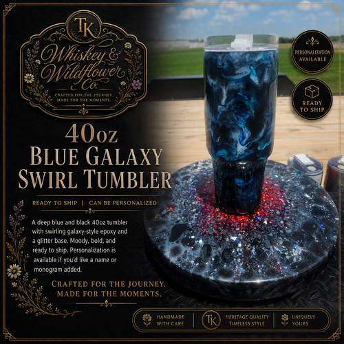 A 40 oz Whiskey & Wildflower Co. Blue Galaxy Swirl Tumbler shown on a dark glittery base with a blue galaxy-patterned tumbler standing in the center.